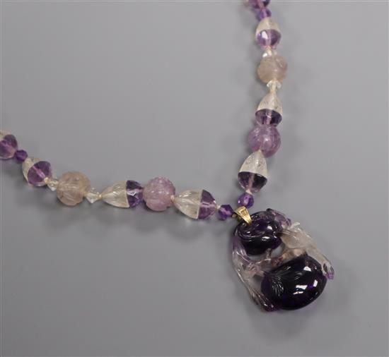 A Chinese amethyst and rock crystal pendant hung from a carved amethyst and rock crystal necklace, pendant 38mm.